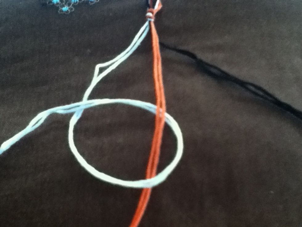 Bring the end of the thread under the center string and over itself. This is a forward knot.