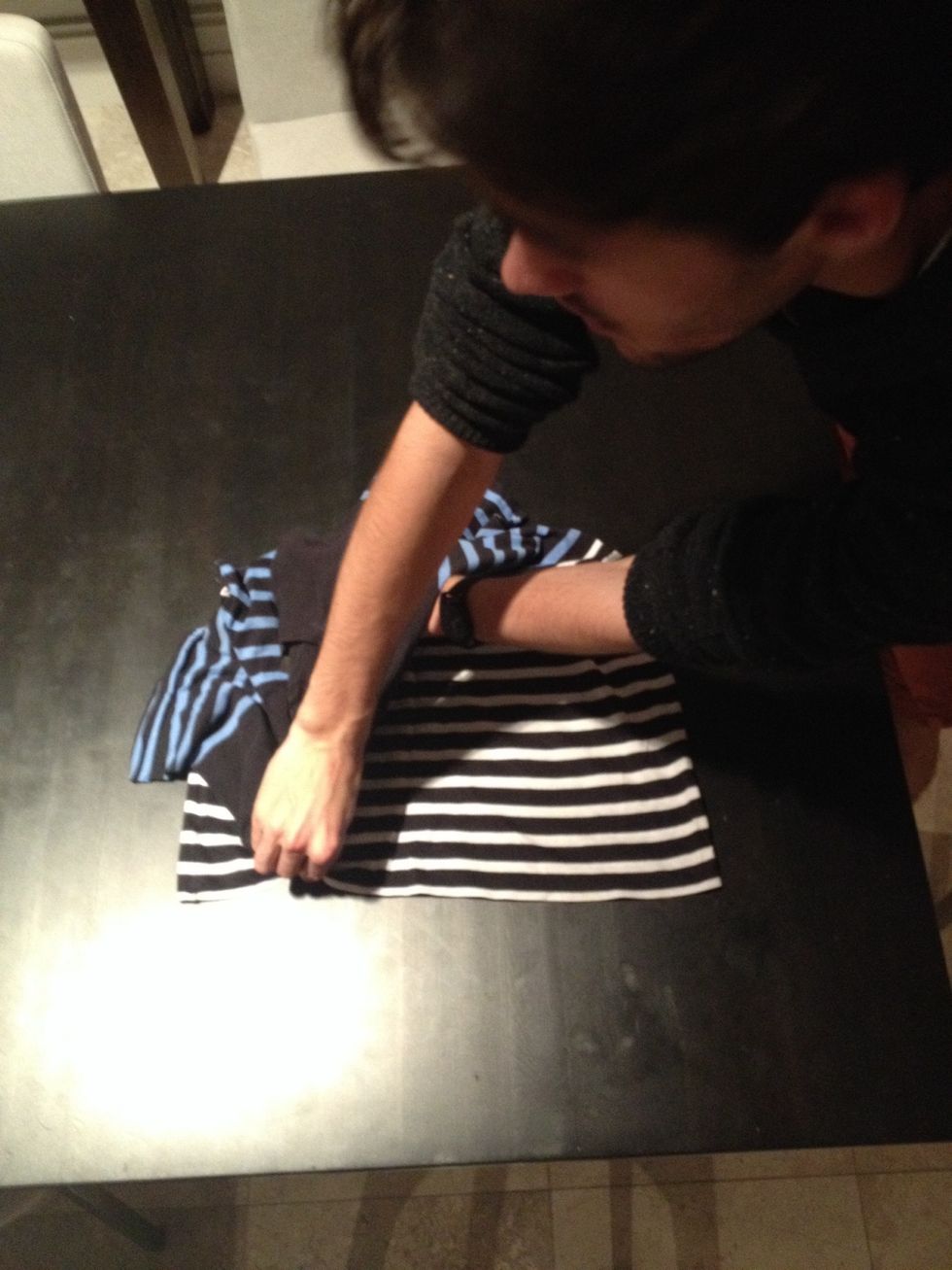 Bring the hand at the top of the t-shirt directly to the bottom, keeping the hand in the middle in place