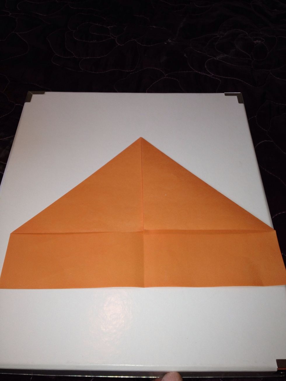Bring the left hand corner into the middle ( like you are making a paper aero plane)