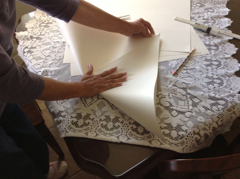 Bring the opposite corners together to form a triangle. Press along the folded edge to form a crease line.