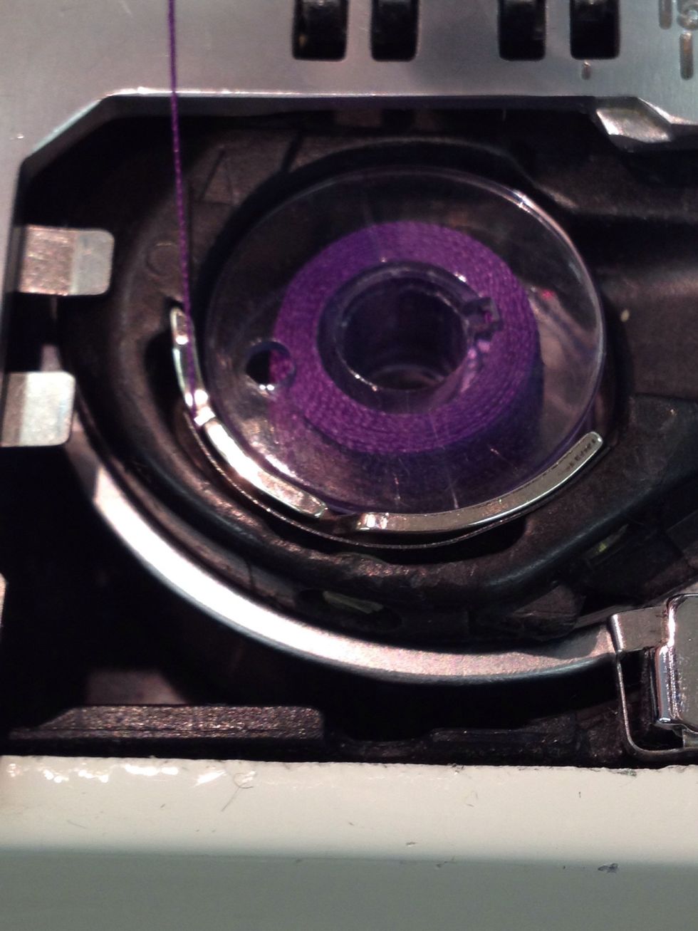 Bring the thread clockwise through the second notch.