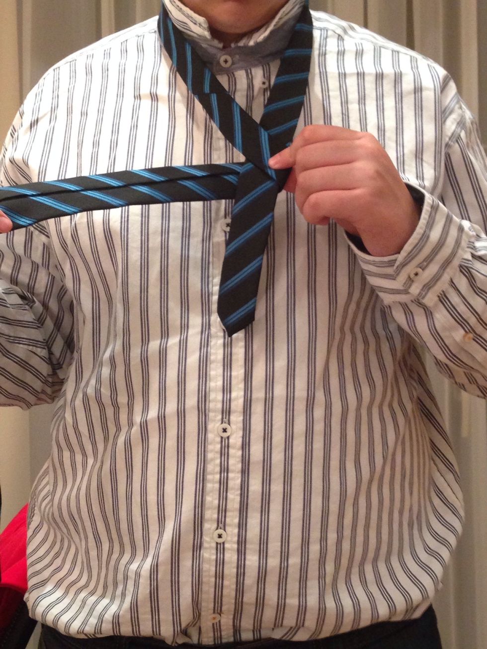 Bring the wide end under the narrow end to the right.