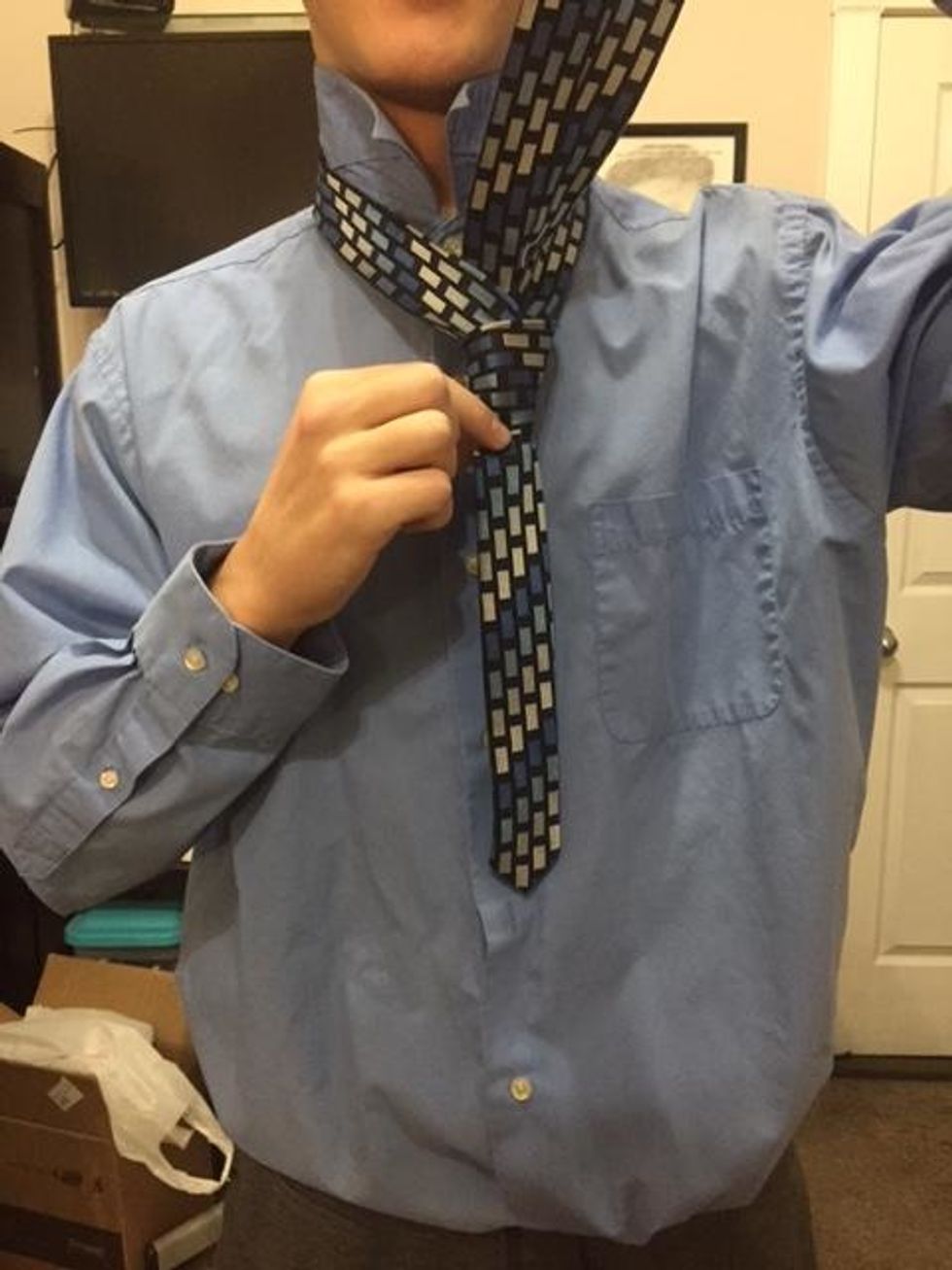 Bring the wide end up through the neck loop.