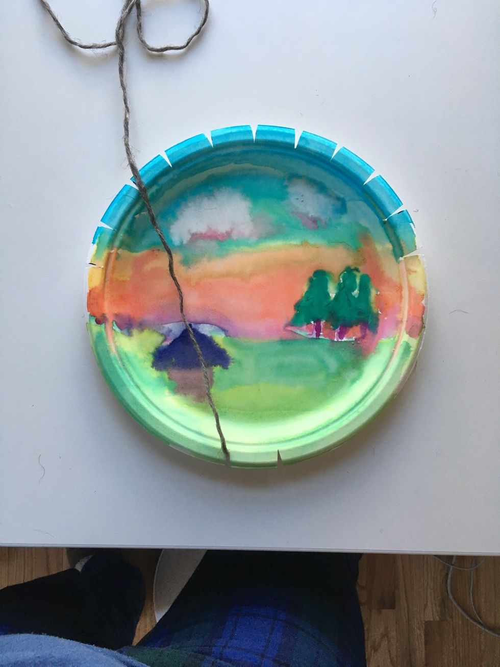 Bring your yarn through the bottom left slot and turn your plate to the front.