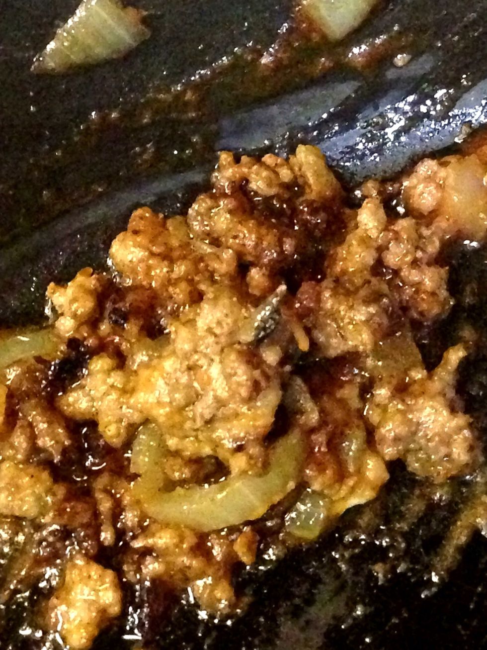 Brown your ground beef with the onions. Drain. Then add the taco seasoning, tomato sauce, green chilies, and refried beans. Stir well to combine.