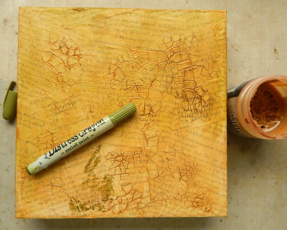 Brush a thin layer of Vintage Distress Collage Medium over the dry background and heat set. Scribble a Peeled Paint Distress Crayon over the dry background and blend with your finger or a dry sponge.