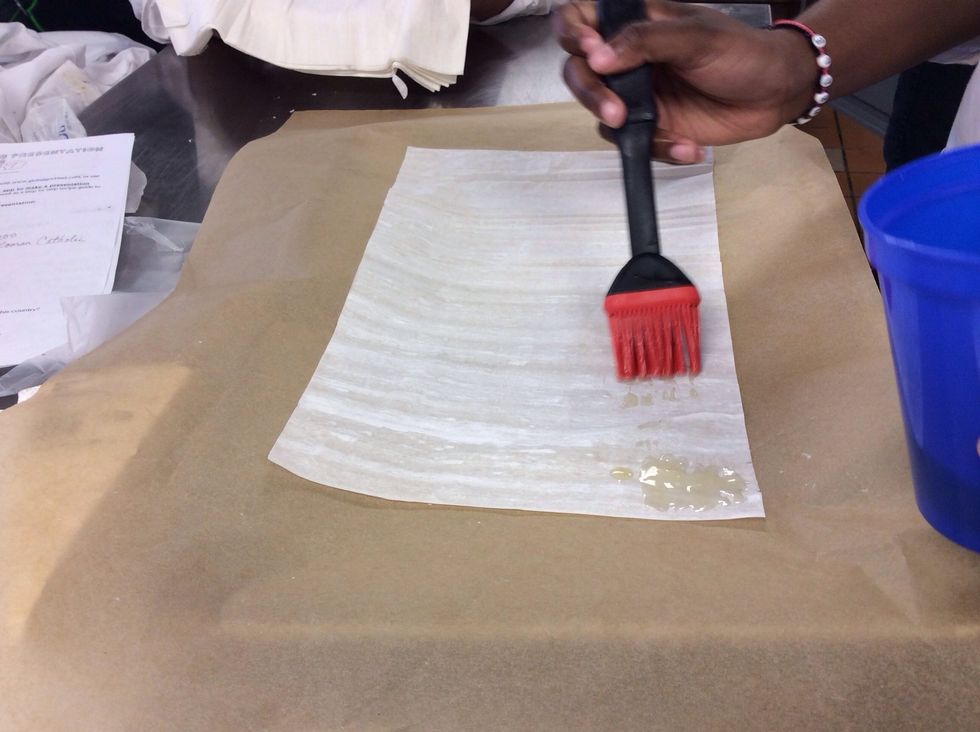 Brush butter on the edges of the sheet of dough