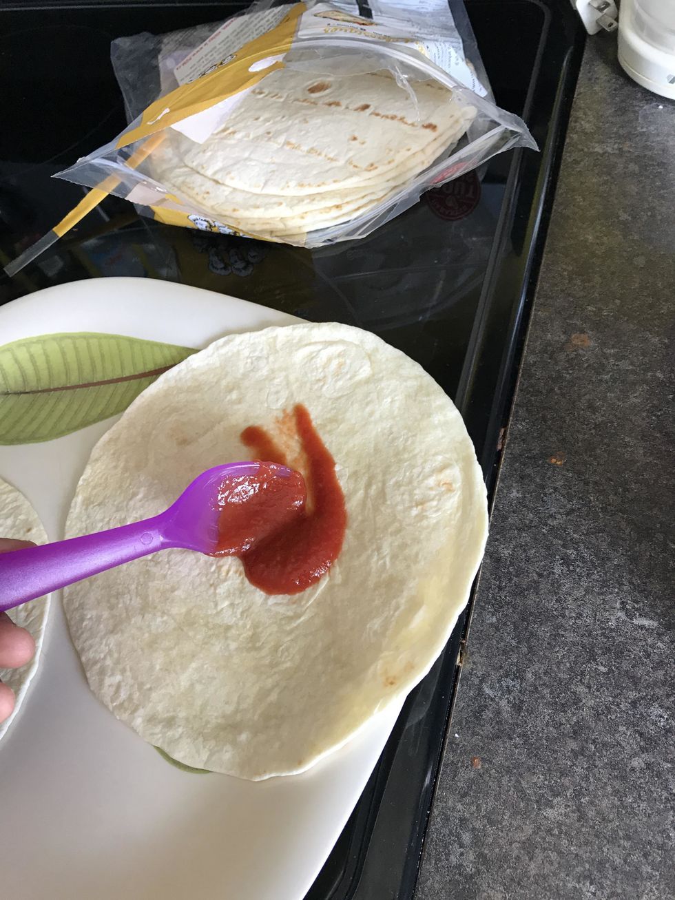 Brush each tortilla with a thin layer of pizza sauce (so thin that if you turned it over, none would drip)