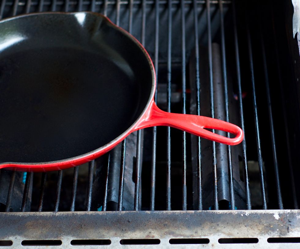 Brush grill grates clean, and set a 12" cast iron skillet on top to heat.