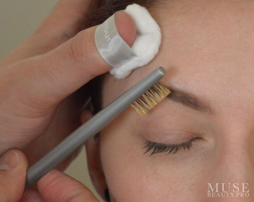 Brush the brow hairs into place. Here we are using the ESUM Pinky Puff and the ESUM P17 Brow Groom Brush.