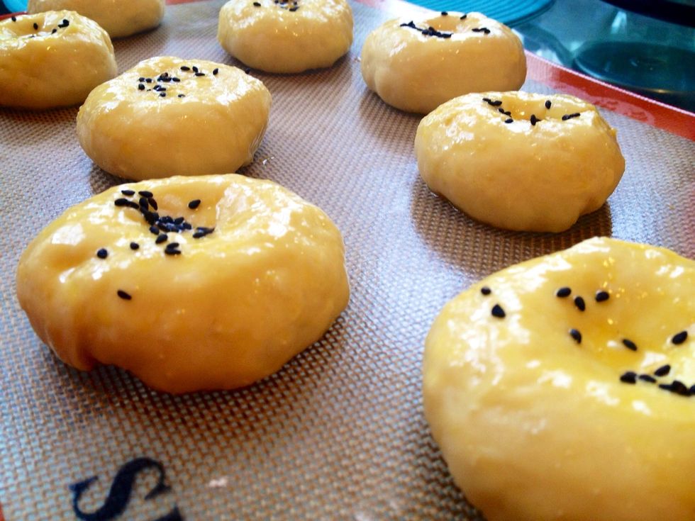 Brush the egg glaze again. Sprinkle black sesame on top (sesame is optional).