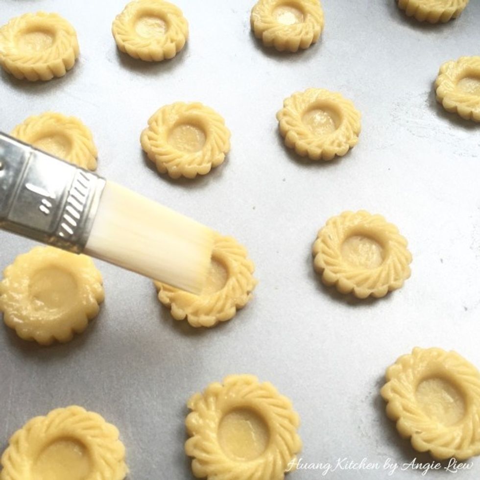 Brush the surface of the tart shells with egg wash.