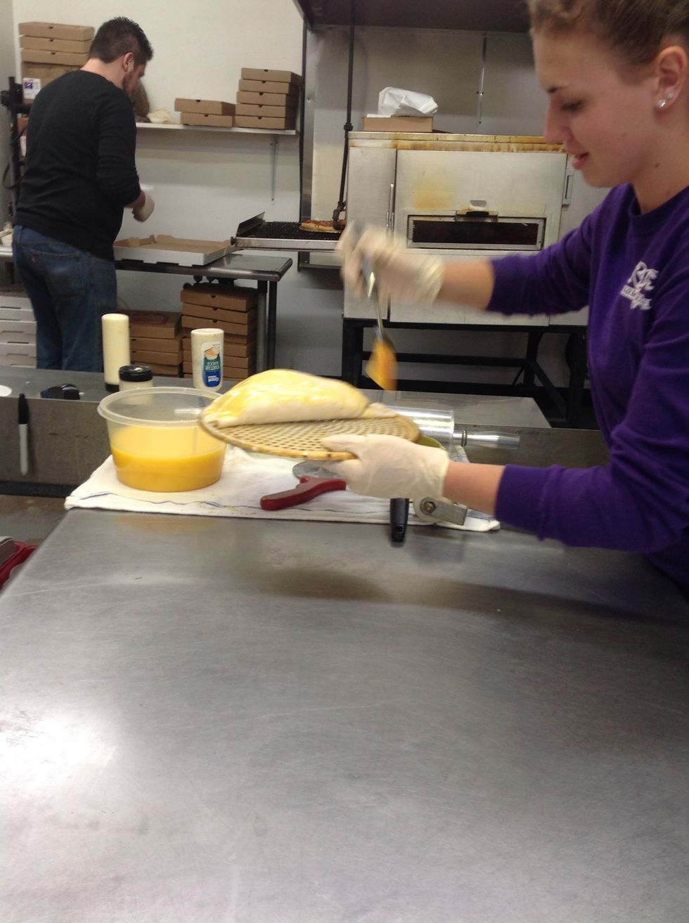 Brushing garlic butter over the top of the calzone