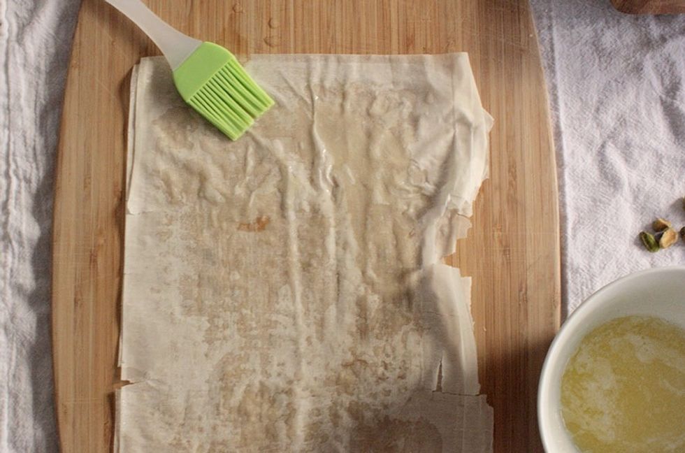 Brushing phyllo with melted butter.