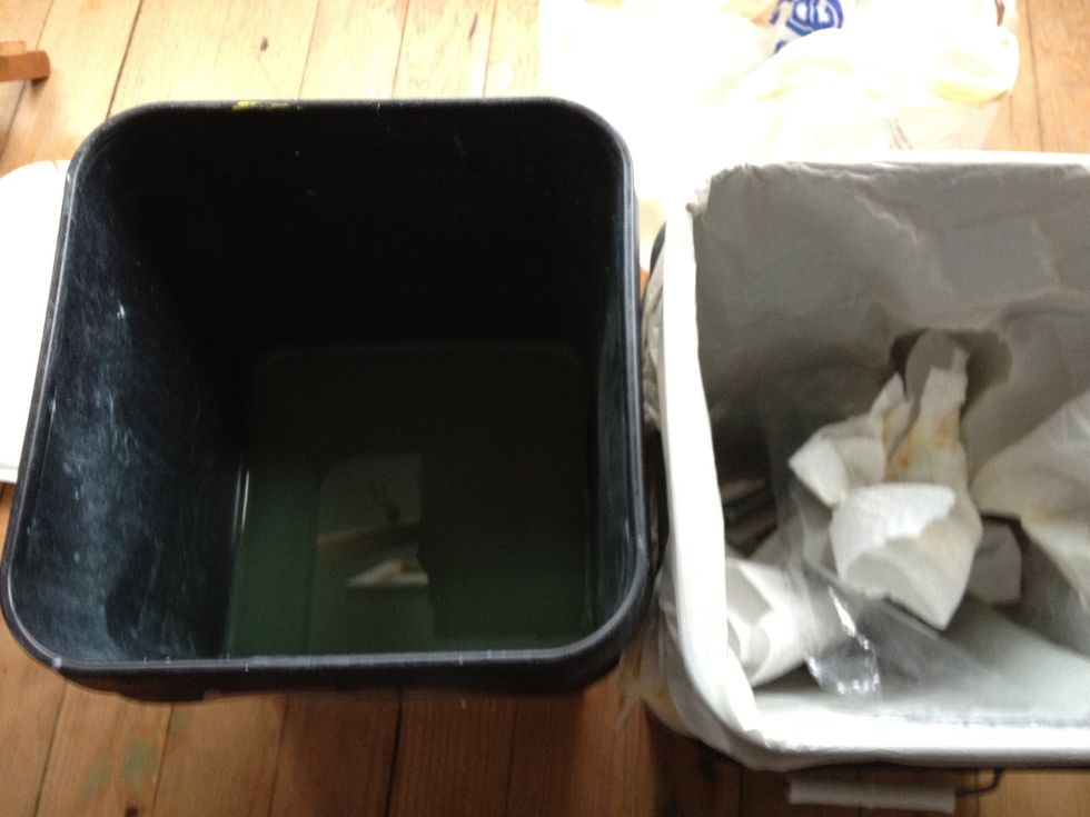 Buckets to clean brushes. The left has a 4 inch plumbing drain in it and is filled with thinner. You can run the brushes over the drain to clean them off, then shake them into the empty can.