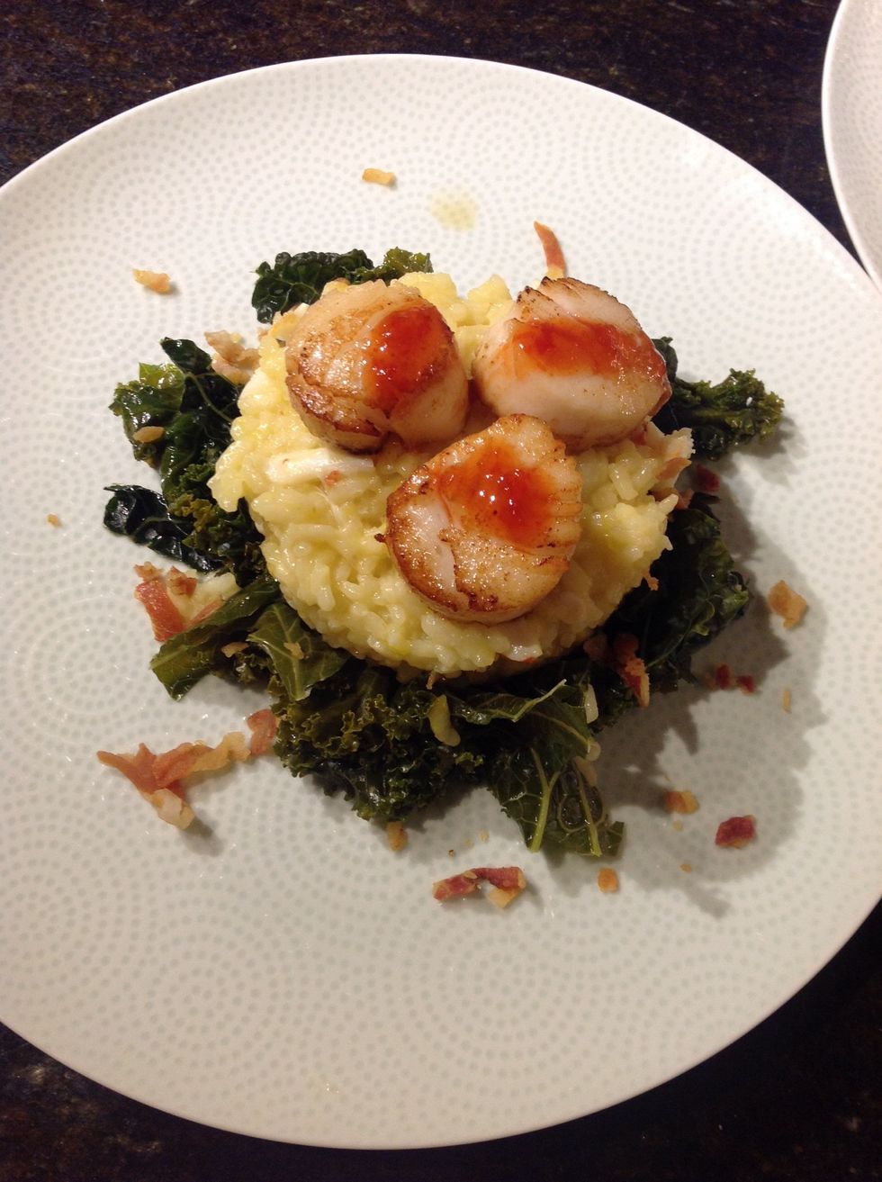 Build your plates by using kale as the base, a ring to form the risotto and top with scallopes.  Drizzle sweet chili sauce and sprinkle edge with pancetta.  Serve immediately with a nice Chardonay.