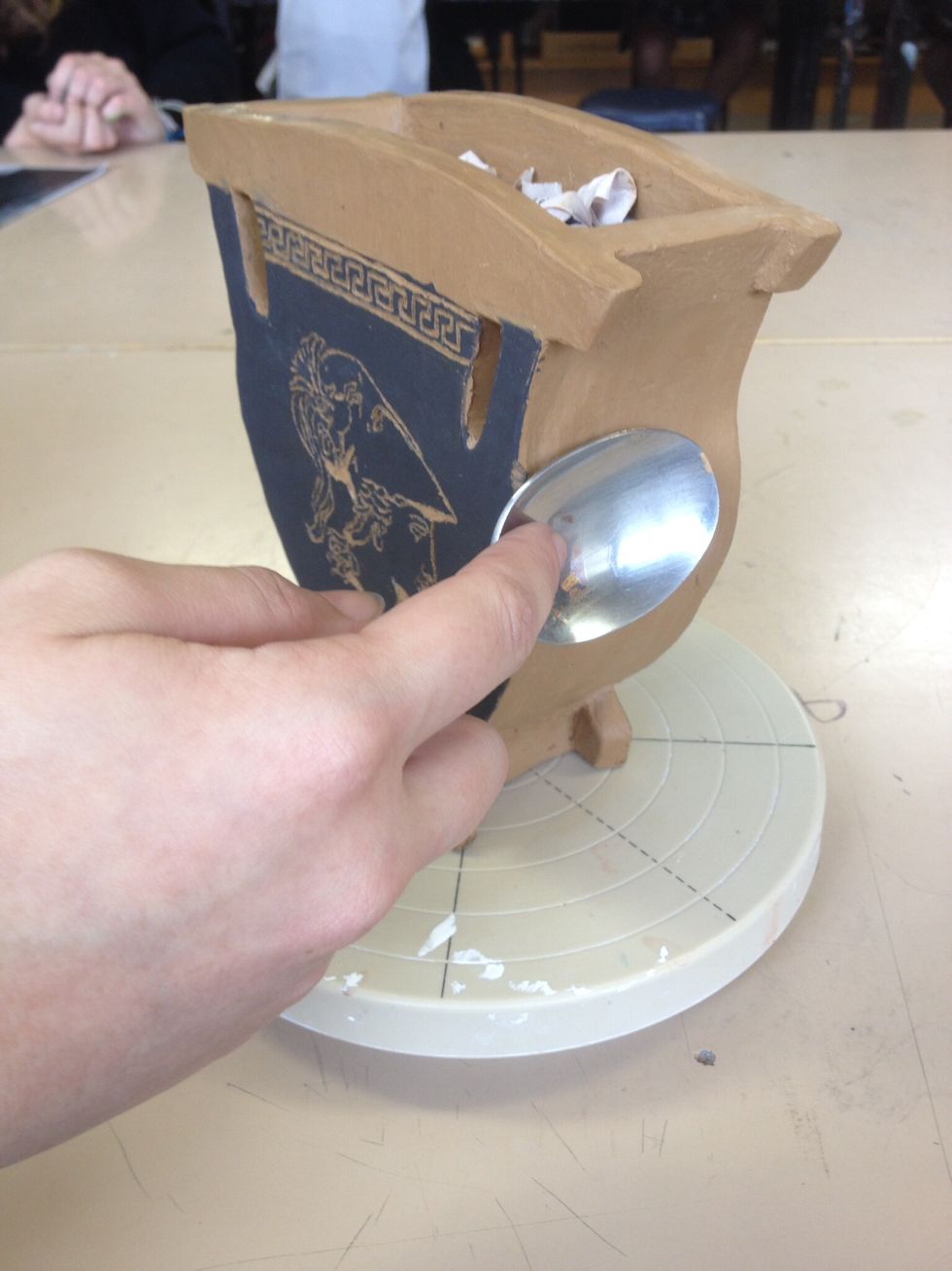 Burnish exposed areas of clay with a spoon or curved wooden clay tool. Polish in circular motions till desired smoothness is achieved.