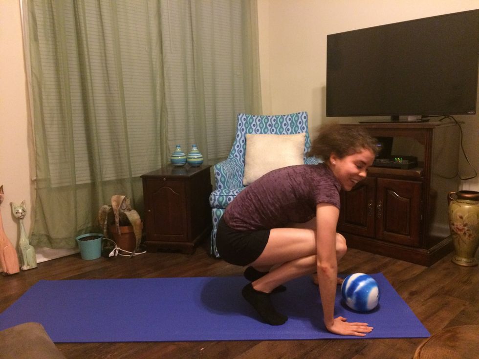 Burpee: Jump to the front of your mat and grab the ball.