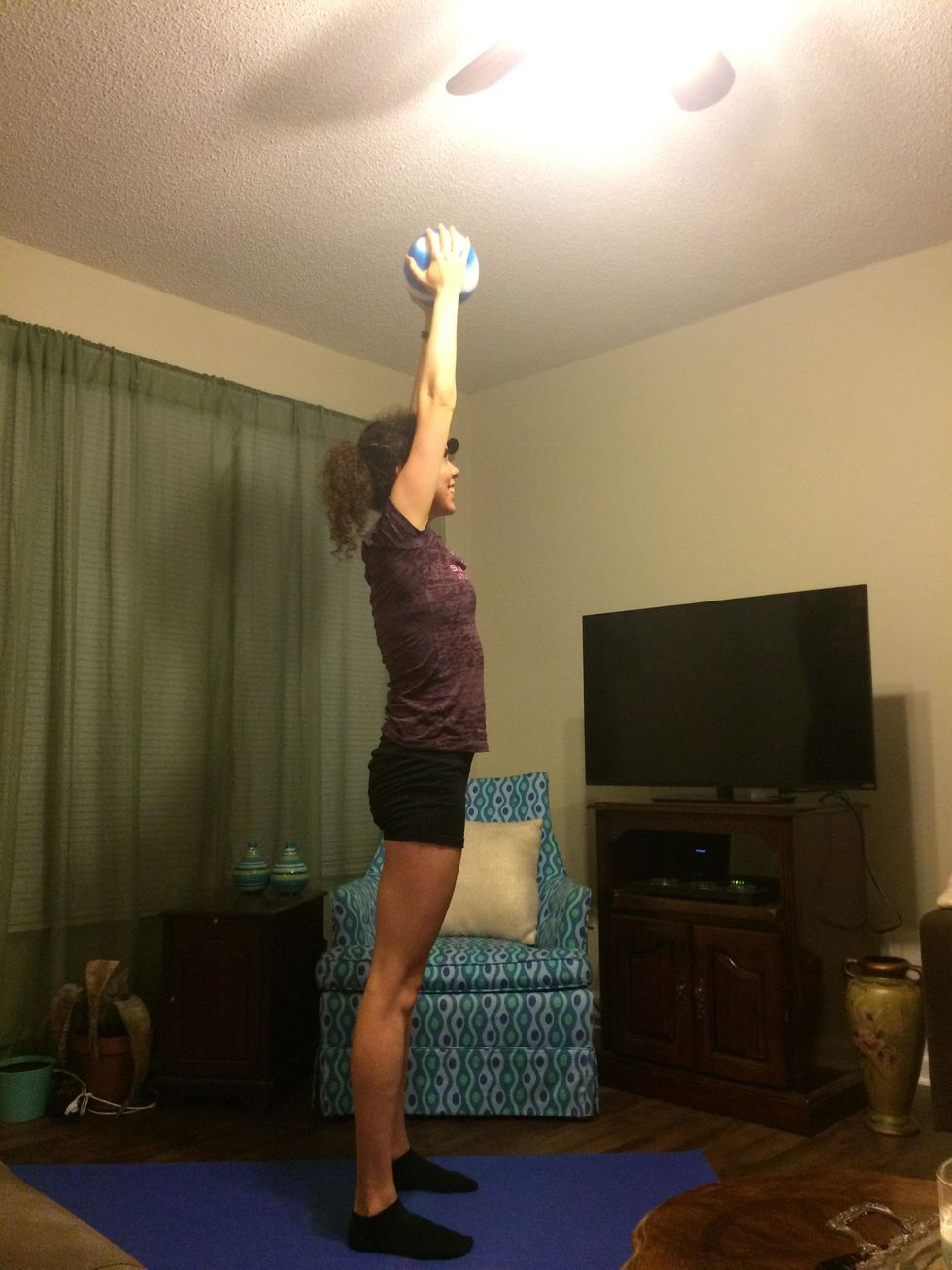 Burpee: Stand up, lifting the ball over your head.