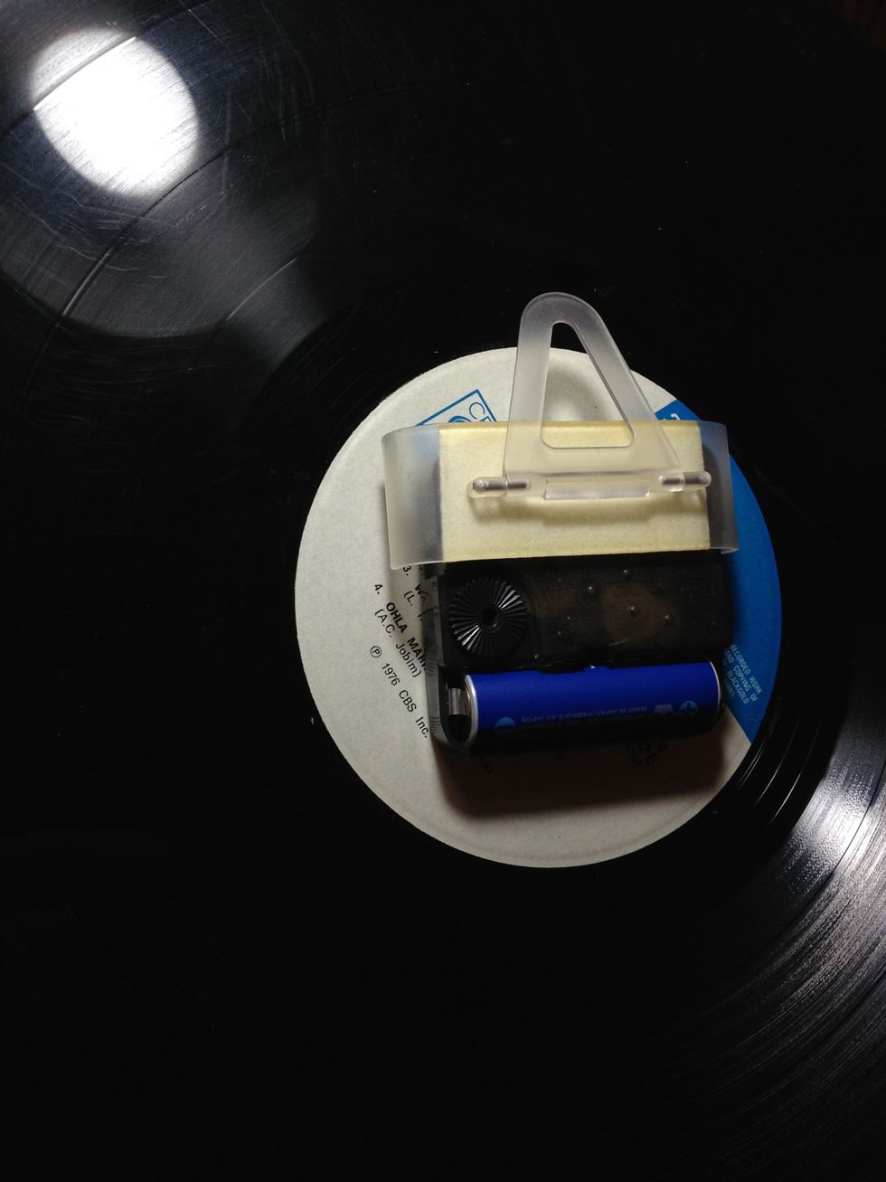 But, if you're like me, I'd like to hang it near my turntable. Attach an improvised hook to do so. Any junk would do. Here, i used an old iPod Touch accessory; a stand that came with a casing.