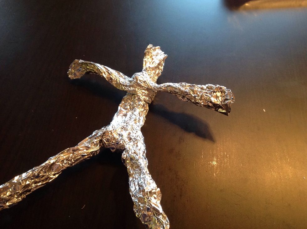 But your figure needs arms, rip another piece of foil, not as big as the first two. Press it into the shape of arms and wrap them around the body.