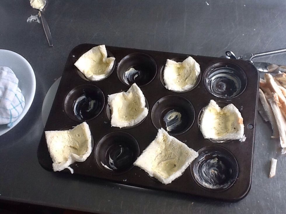 Butter the cupcake trays, then put the buttered bread in to the cupcake tray!as shown
