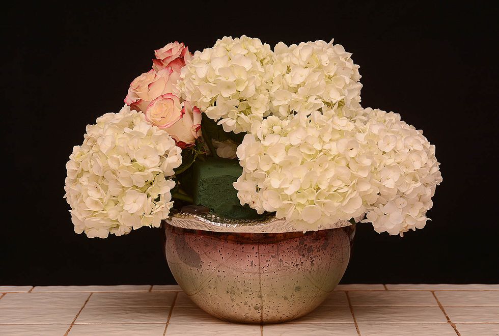 By adding the roses, we add contrast in color, shape and texture. They also provide another prestige flower to the arrangement\u2026.