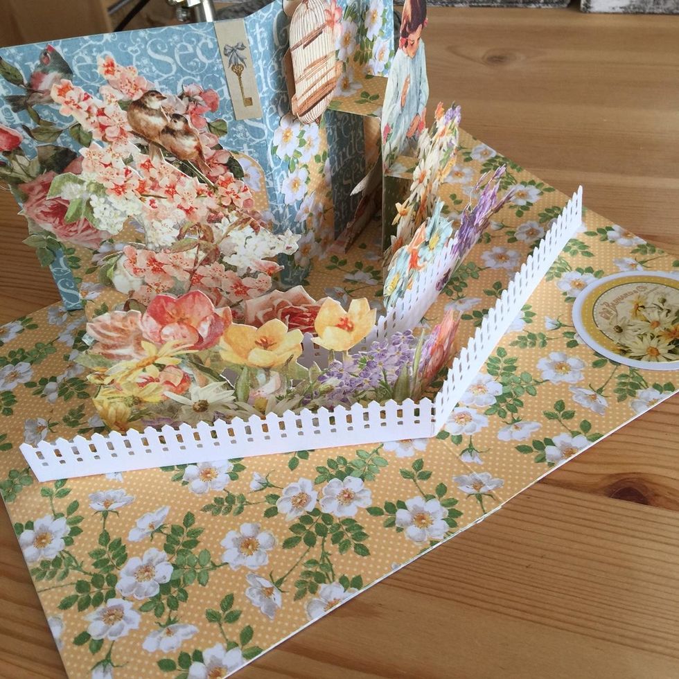 By last glue another fence on the front and decorate glueing flowers.