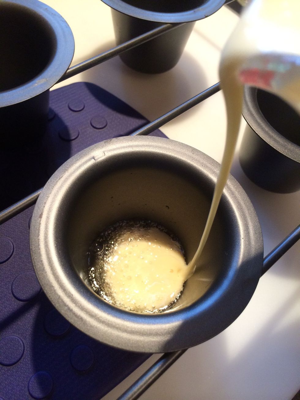 By now the oven should be fully preheated. Remove pan from hot oven and divide batter between the 6 cups.