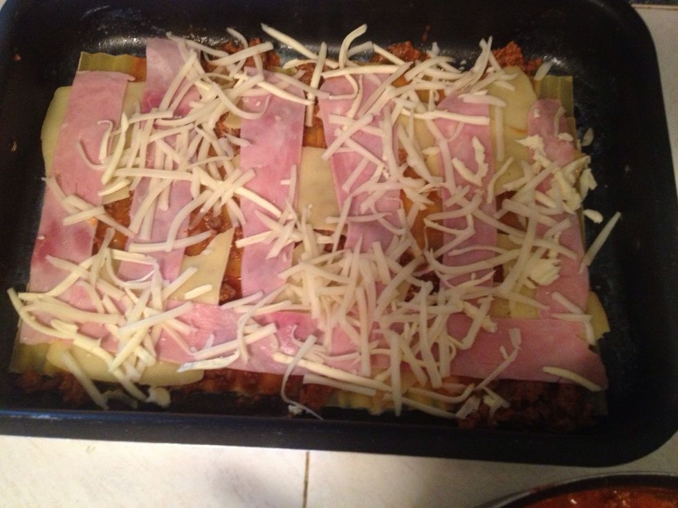 Capas de pasta, salsa bechamel, carne, queso amarillo y jam\u00f3n