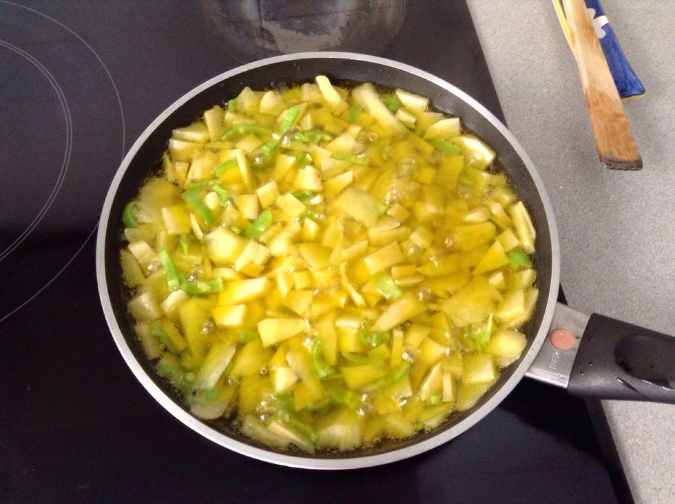 Carefully, add the potatoes, peppers & onion mixture into the frying pan. Spread them as much as you can. They will be ready when they are tender.