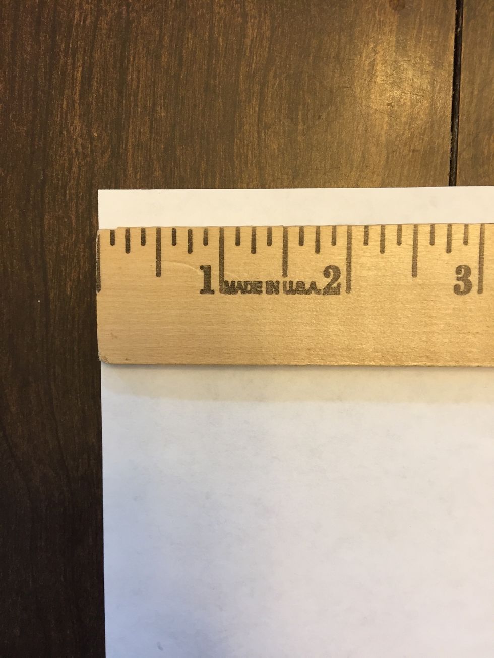Carefully align ruler along the long edge of paper. Make sure the end of the ruler is right at the edge of the paper.