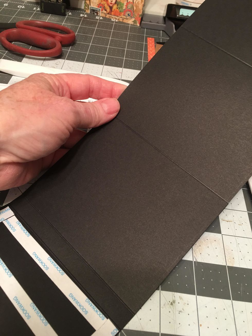 Carefully attach ONE of the long fold out page sections to the hinge piece as shown. You will attach only one end section. Make sure to line it up on all sides.