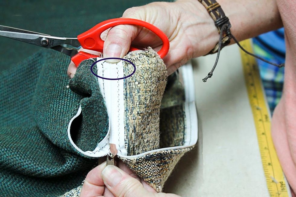 Carefully clip the stitches that are securing the fabric stop at the end of the zipper.