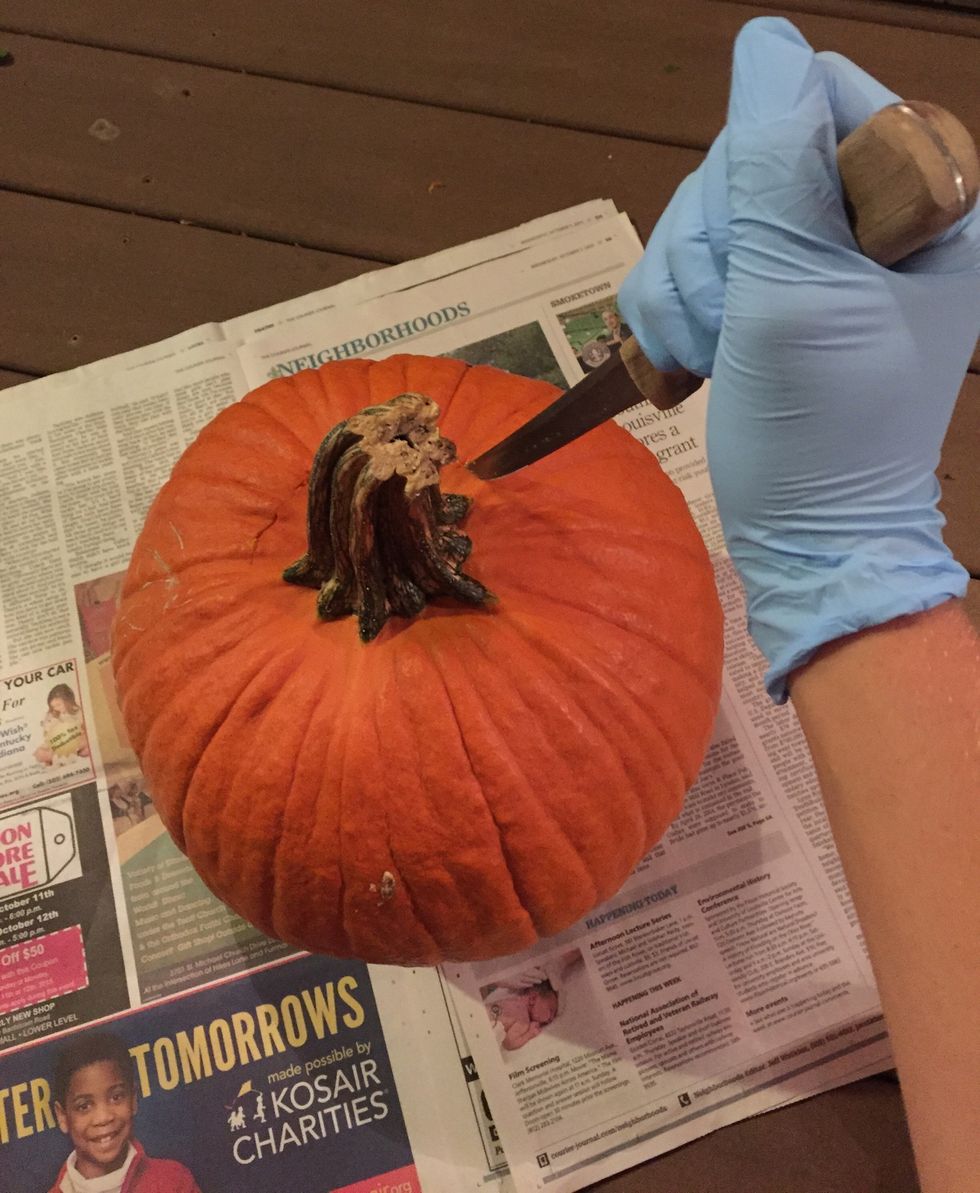 Carefully cut around the top of the pumpkin until you make a complete circle. Once you have made the cut, pull the stem so the top piece can be removed.