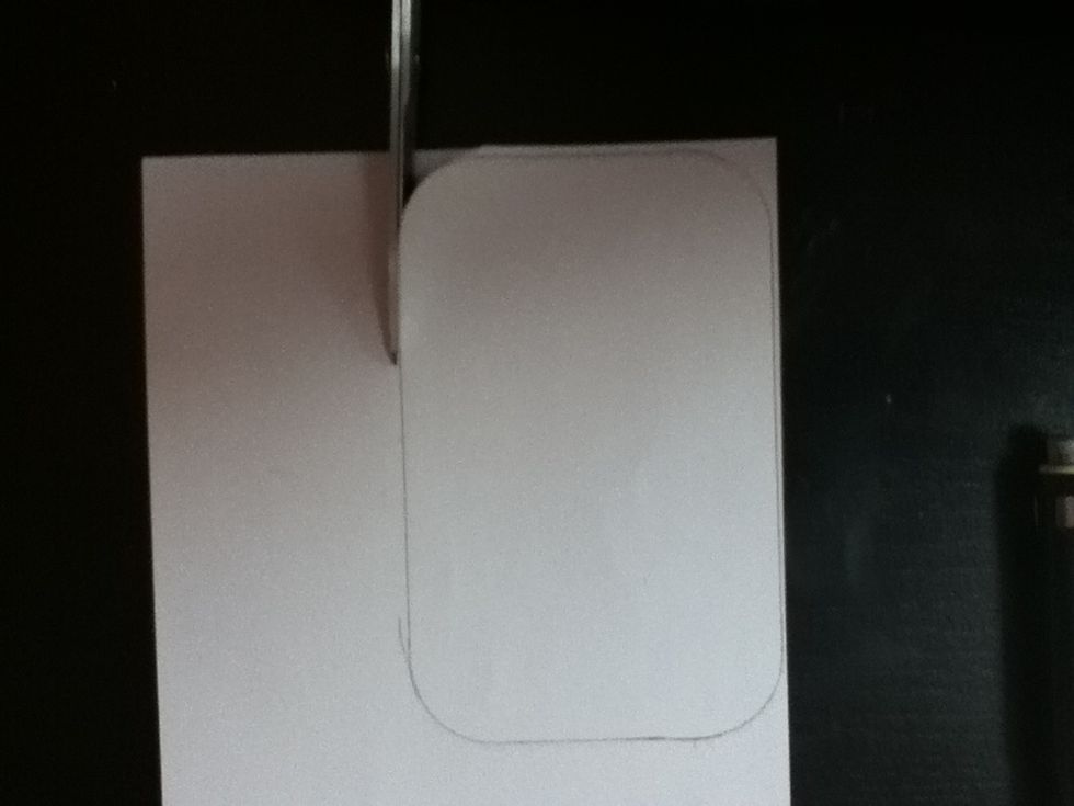 Carefully cut out the shape that you have traced. Now place your cutout on the cover of your tin to check the fit. Trim it down slightly if needed.