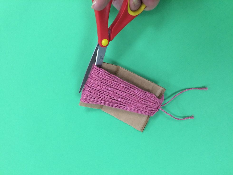 Carefully cut the bottom yarns. Let your scissors follow the line of the cardboard.