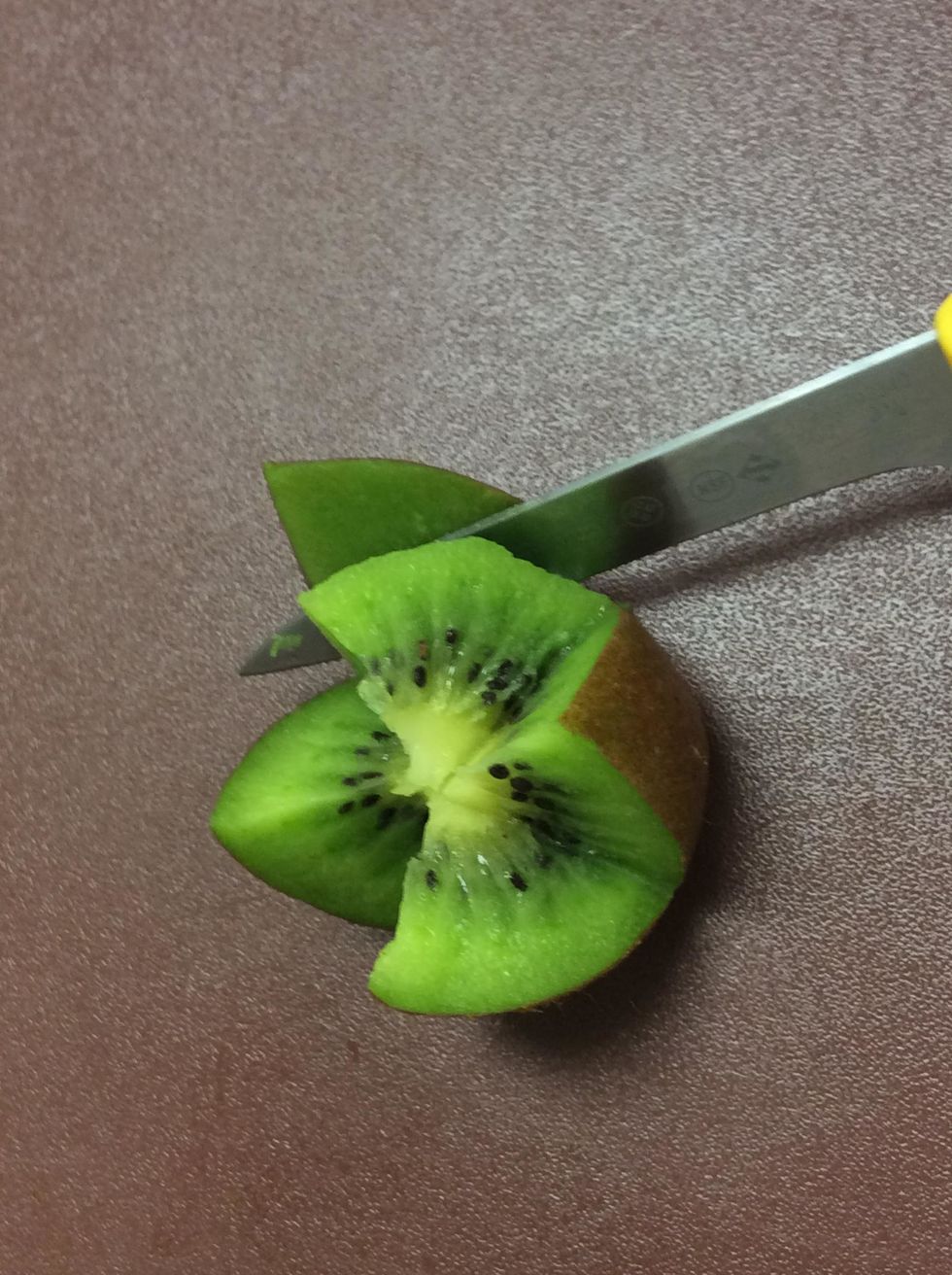 Carefully cut the brown skin but not all the way. You want to leave it attached to the kiwi.