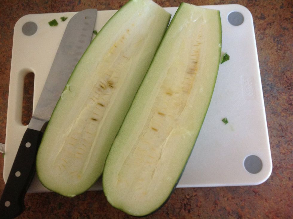Carefully cut the zucchini in half
