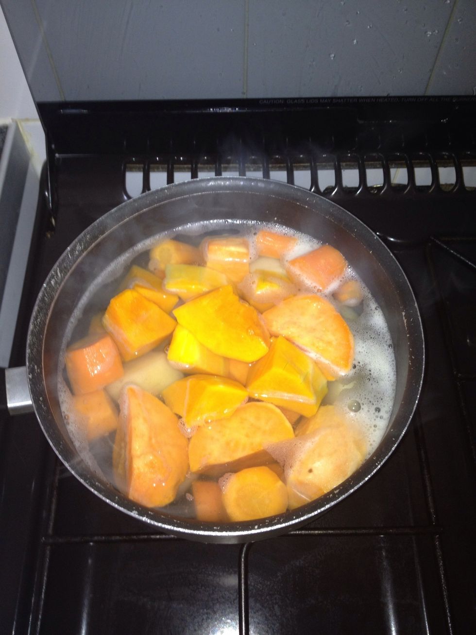 Carefully peel and chop the potatoes, carrots and butternut squash and place them into the boiling water. Keep on medium heat.
