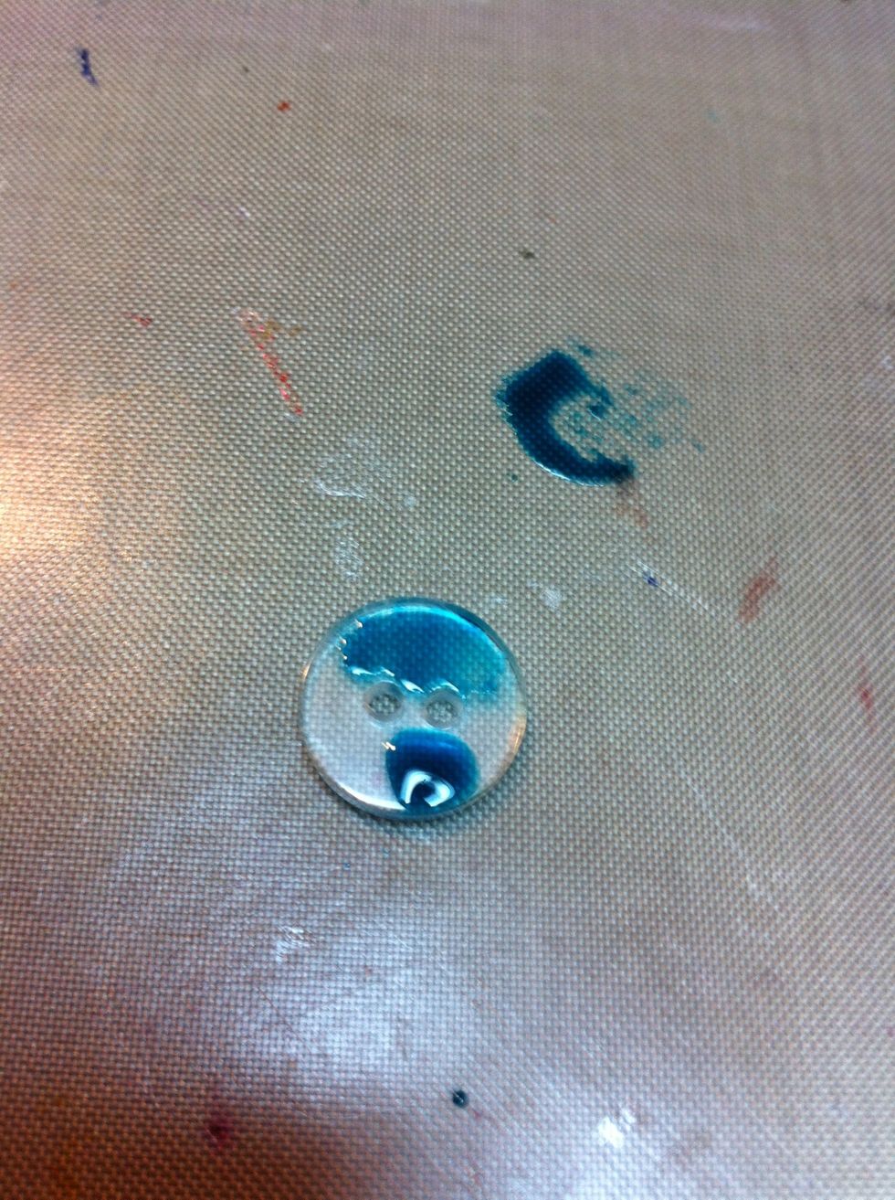 Carefully place tip of alcohol ink onto one side of button and drop a little ink on the button. Be sure not to add too much. You don't want it spilling over the sides.