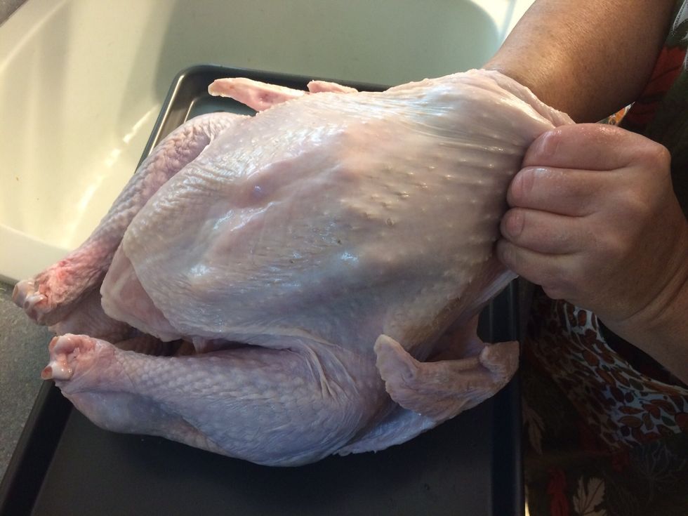 Carefully pull the skin from the meat...then place the slices of oregano & lemons under the skin.