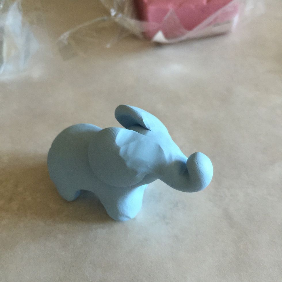 Carefully, push the clay towards the side of the elephant's face to mold the disk into the face. Using a pen to roll out the disk into the face slowly may help create a smoother look.