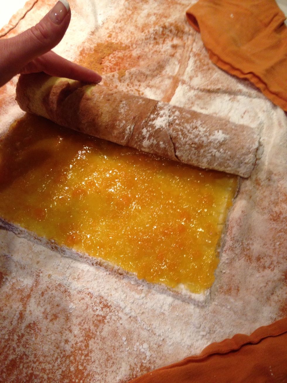 Carefully roll up the cake, apply enough pressure to form a tight cake roll, but not so much that the jelly oozes to the edge.