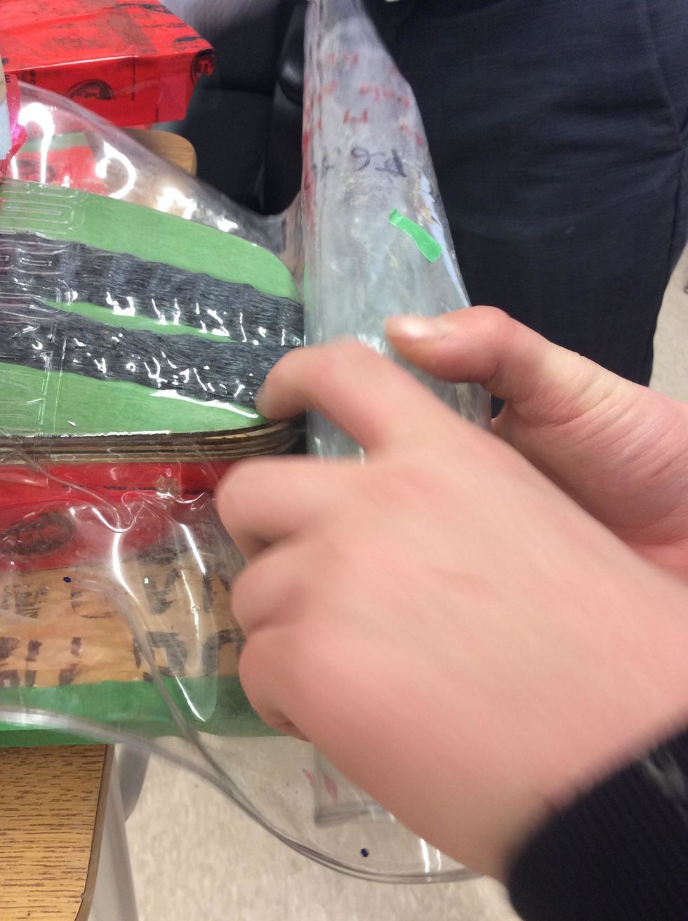 Carefully roll up vacuum bag on the tail end of veneers.