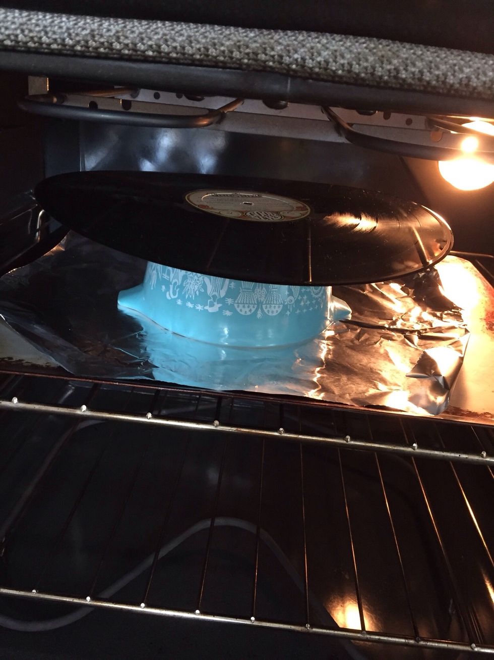 Carefully set in oven.  The vinyl will get 'bendy' very quickly, only leave it in for a few seconds