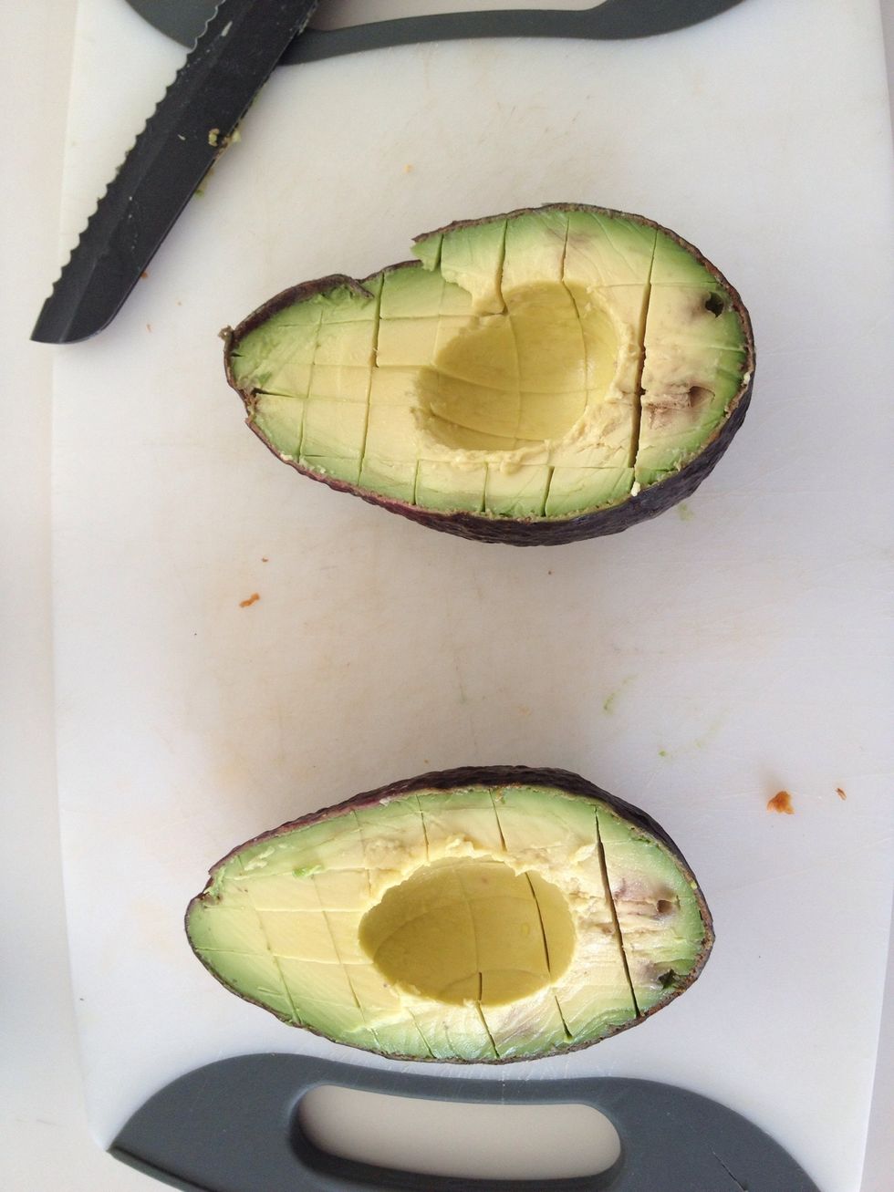 Carefully slice avocado vertically, then horizontally to create squares. Be careful not to cut through the skin.