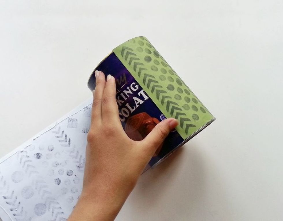Carefully start to wrap the paper around the can.