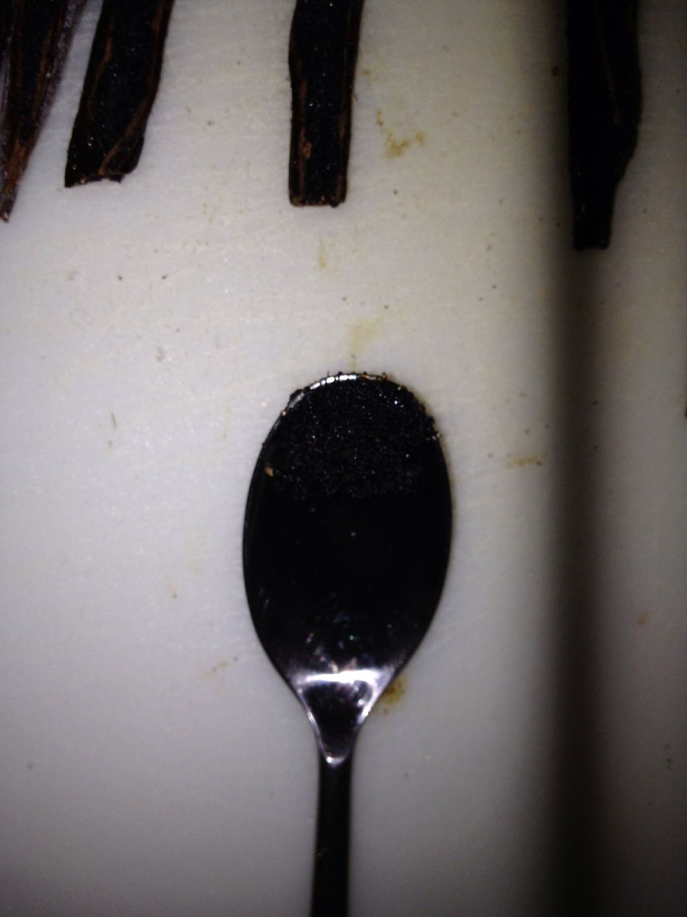 Carefully take a spoon and scrape out the seeds of the vanilla bean going in one direction, which is easier. after scraping every bean, take the spoon and wipe off the seeds on the storage container