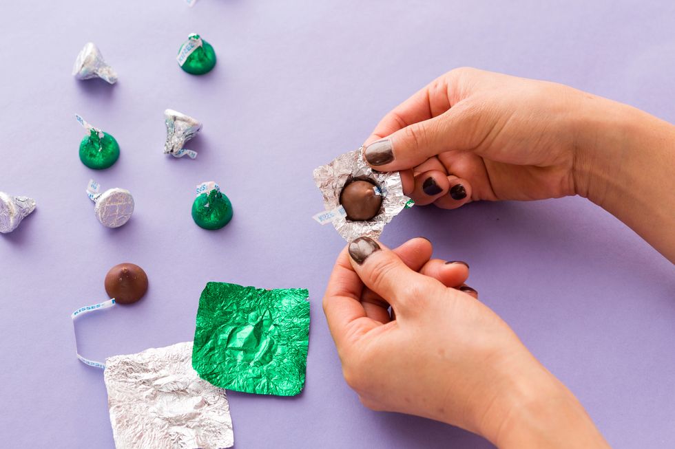 Carefully unwrap the green and silver foils. Don\u2019t forget to pop the chocolates in your mouth as you go, or you can melt them down to make holiday bark.